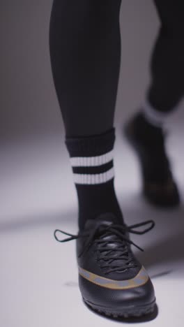 Vertical-Video-Close-Up-Studio-Shot-Of-Female-Footballer-Tying-Training-Shoes-Or-Football-Boots-2